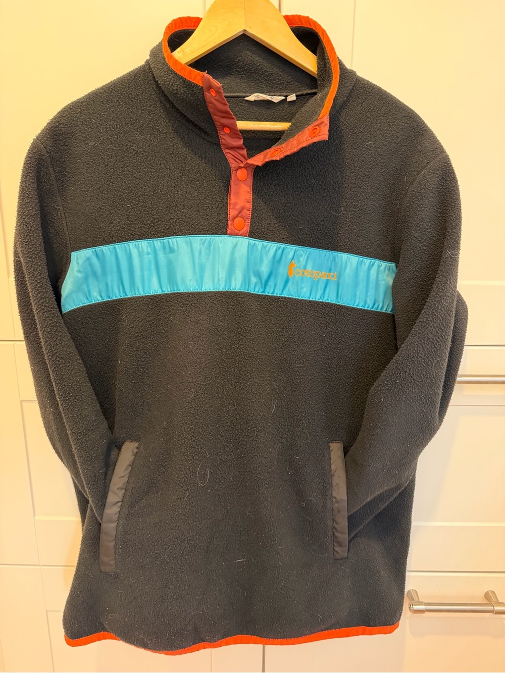 Cotopaxi Black Fleece Pullover with Teal Panel and Orange Trim